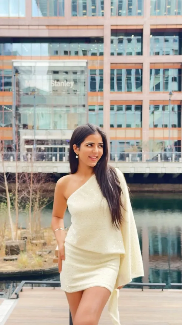 The video features a woman getting ready for brunch, applying makeup and jewelry. She then transitions to an outdoor restaurant setting where she shows plates of food including quesadillas, a burger with fries, and various drinks like an espresso martini, orange juice, and a cocktail. The video includes text overlays discussing the cost of brunch in London compared to India.