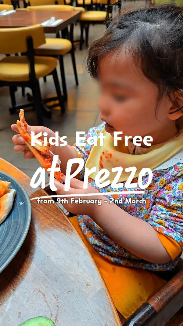 The video promotes Prezzo, an Italian restaurant, highlighting their 'Kids Eat Free' offer. It features shots of various dishes including calzone with salad and tomato sauce, pizza, spaghetti bolognese, fried shrimp with aioli, and dough balls with a dipping sauce. The food is presented on grey plates and wooden tables. The video also shows the exterior and interior of the restaurant, including the bar area, dining area with a glass ceiling, and a wood-fired pizza oven. A child is shown eating pizza and cucumber, and an adult is shown eating spaghetti bolognese. The main focus is on showcasing the restaurant's ambiance and the variety of Italian dishes available, emphasizing the family-friendly 'Kids Eat Free' promotion.