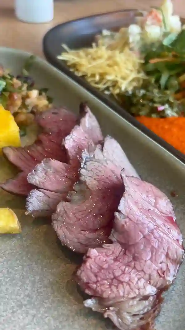 The video showcases a meal at Preto Restaurant in Putney, London. It features various grilled meats (beef, chicken, pork) served on skewers, along with sides like fries and salad. The meats are presented on skewers, sliced and served by staff. The video emphasizes the abundance and quality of the food, highlighting the all-you-can-eat nature of the Rodizio Grill. The overall vibe is energetic and enthusiastic, focusing on the dining experience.