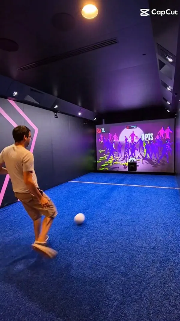 The video showcases Toca Social, an interactive football experience located in Birmingham's Bullring. It features people playing various football games projected onto a screen, with different game modes and difficulty levels.  The venue's interior is highlighted, showing its modern and sleek design, and mentions a food and drinks menu although no food or drinks are shown in the video. The video focuses on the interactive football experience and its suitability for families, couples, and birthday parties.
