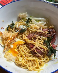 Smokey bavette noodles with pickles, pork puffs, egg, and garlic broccoli from Ling Ling's meal kit for Lunar New Year.