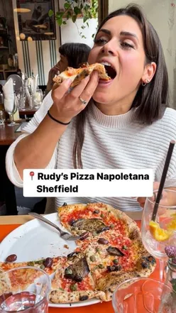 Sourdough pizza with aubergine, capers, vegan cheese at Rudy's Pizza Sheffield, paired with Aperol Spritz and Nocellara olives.