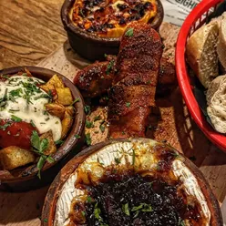 Camembert bar at Neighbourhood Kitchen Cardiff with Le Rustique Camembert, Welsh Perl Wen, pigs in blankets, patatas bravas, and bread.