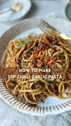 Spicy garlic chilli pasta in a pan, topped with crispy onion and garlic, perfect for a quick, budget-friendly vegan meal.