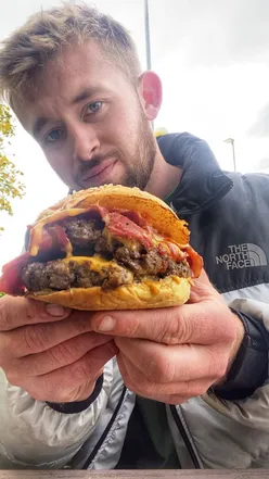 Double cheeseburger with melted cheese and crispy fried chicken, perfect for burger lovers and street food enthusiasts.