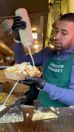 Halal cheesy chips with cheese sauce at Funky Chips Camden Market, London. Perfect for chips lovers and halal foodies.