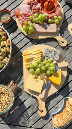 Colorful charcuterie platter with meats, cheeses, grapes, and olives, perfect for sharing at a budget-friendly price.