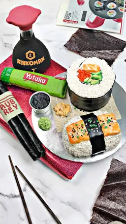 Chocolate orange sushi cake with fondant, resembling sushi rolls, on a plate. Vegan dessert, citrus, and chocolate flavors.