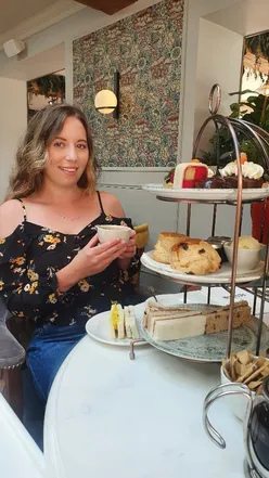 Child enjoying carrot cake with creamy buttercream at The Manor Greasby, surrounded by elegant wall art and relaxed atmosphere.