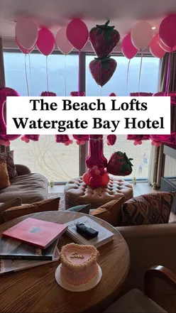 Beach loft at Watergate Bay, Newquay with ocean view, birthday balloons, and cake from Ladyvale Bakery, Cornwall.