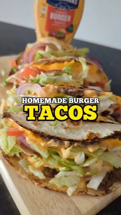 Delicious burger tacos filled with cheese and sauce, perfect for food lovers craving a unique twist.
