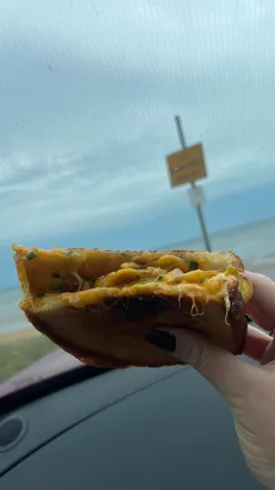 Grilled cheese toastie with melted cheese oozing, served at The Cheesy Toast Shack in St Andrews, Scotland.