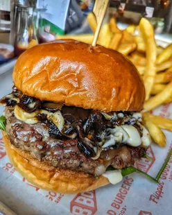 Juicy Wagyu cheeseburger with raclette, caramelized onions, and cheesy fries at Hubbox Dorchester.