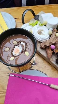 Creme Egg Fondue with mini eggs, waffle fingers, mallows, and fruit at Brel Glasgow, perfect Easter treat for chocolate lovers.