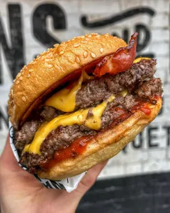 Double beef patties burger with smoked bacon, house bacon jam, triple American cheese, and Heinz smokey ketchup at Nanny Bills.
