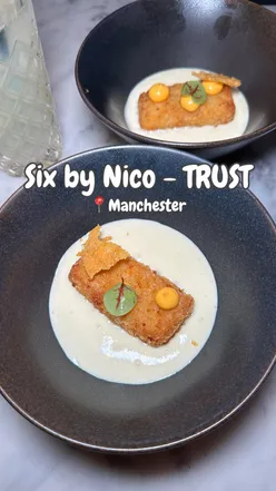 A beautifully plated dish from the TRUST menu at Six by Nico, showcasing vibrant colors and textures.