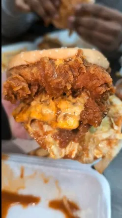 Double spicy dipped chicken burger from @chickenspice.uk, showcasing crispy fried chicken and vibrant toppings.