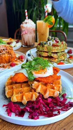 Delicious brunch spread featuring pancakes, chicken waffles, and a Kinder Bueno milkshake at Hokka Brasserie.