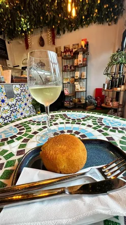 A glass of wine and arancini at Ciaro Italian Deli by Birmingham Canal, perfect for food lovers.