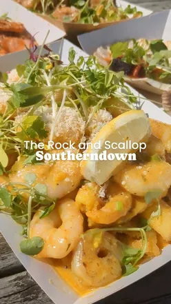 Delicious seafood feast featuring loaded chips, garlic king prawns, surf and turf, and hand dived scallops.