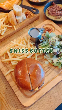 Delicious Swiss Butter dishes: beef fillet, chicken, salmon with fries, baguette, salad, and creamy sauce.