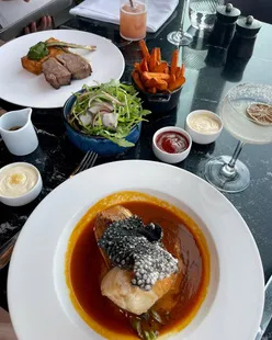 Dinner at 20 Stories Manchester with city views; dishes include crispy duck salad, seared beef tataki, BBQ lamb rump, spiced cod loin, strawberry pavlova, and chocolate torta caprese.