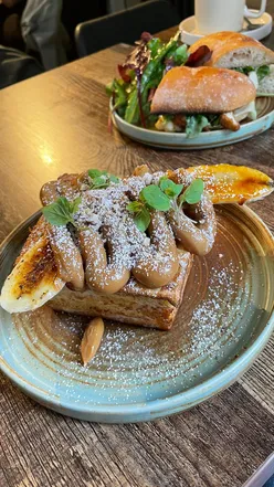 Brunch at Serendipity: dulce de leche French toast with caramelized banana, crispy chicken sandwich, flat white, and latte.