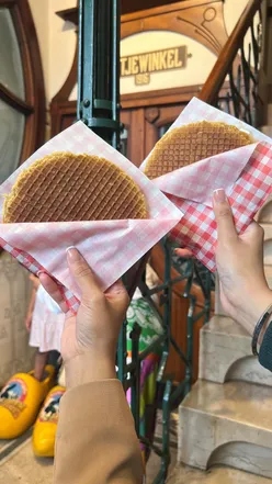 Freshly made Stroopwafels at Stroopperie Amsterdam, showcasing classic waffle with hot caramel sauce. Amsterdam dessert delight.