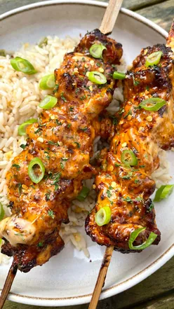 Delicious bang bang chicken skewers ready for air frying, featuring marinated chicken thighs and spicy sauce.