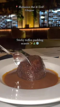 Sticky toffee pudding on a plate, part of Malmaison Hotels' autumn winter menu, offering cozy, comforting vibes.