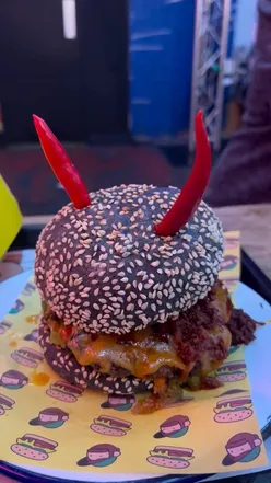 Halloween special burger 'Beelz-Burg' with black bun, spicy chicken nuggets, and raspberry water at Richie’s.