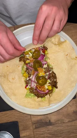 Delicious pulled pork wraps with mango salsa, guacamole, and jalapeรฑos, perfect for a cozy Sunday night.