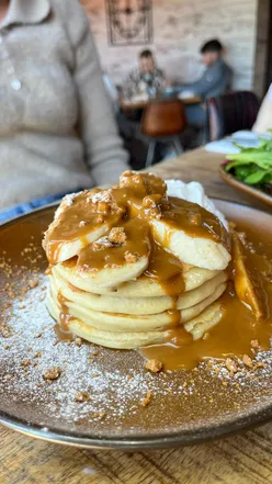 Stack of fluffy pancakes topped with syrup at Residence Cookridge, perfect for brunch or dessert in Leeds.