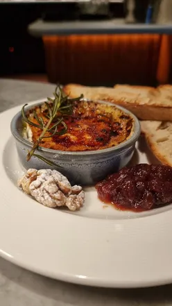 Brulée Camembert with grape chutney and walnuts at Cote Edinburgh, served with toasted sourdough and fork.