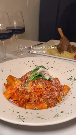 Delicious Italian meal at Cyrus Italiano with excellent service, featuring pasta and wine. Inviting dining experience.