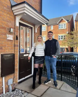 Happy couple celebrating their new home with a house key, excited for their next chapter together.