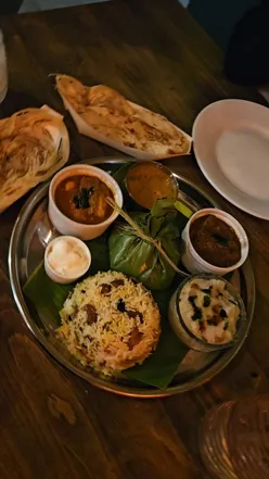 Kerala cuisine feast: Beef Dry Fry, Medhu Vada, Parotta, Chicken Biryani, Kizhi Porotta, chai, lemon cardamom tea, cocktails.