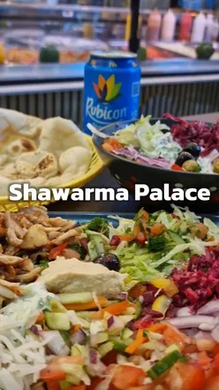Chicken shawarma plate with drink at Shawarma Palace, Birmingham; features fresh bread, diverse salads, and complimentary tea.