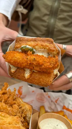 Fried chicken biscuit sandwich with homemade ranch at Cardinal Rule in Manchester, UK. Iconic American street food delight.