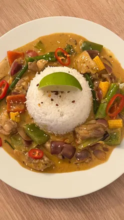 Wagamama's Raisukaree Curry with chicken, red and green peppers, sugar snap peas, garnished with lime and red chili.