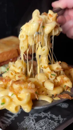 Creamy mac n cheese topped with crispy breadcrumbs, served in a rustic bowl, perfect comfort food delight.