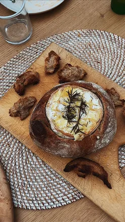 Baked camembert cheese with rosemary on a festive Christmas Eve table, perfect for holiday celebrations.