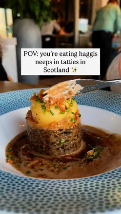 Plate of haggis, neeps, and tatties at Scotts Troon, Scotland, showcasing traditional Scottish cuisine in a cozy restaurant setting.