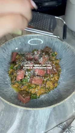 One pot garlic butter steak served over peppercorn rice with broccoli and parmesan, perfect for a hearty meal.