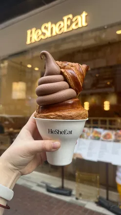 Dark chocolate ice cream in a croissant cone from HeSheEat Cafe, a unique Hong Kong dessert treat for shoppers.