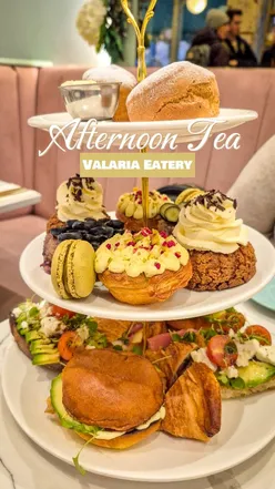 Afternoon tea at Valaria Eatery with scones, clotted cream, jam, avocado toast, blueberry cake, and macarons.