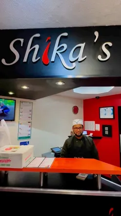 Plate of curry, rice, nargis kebab, and lamb chops from Shika's Indian Takeaway, a renowned Bangladeshi eatery in Birmingham.