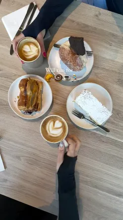 Oat milk latte, oat milk flat white, sausage roll, vanilla slice, and chocolate donut at canal side cafe in Leeds.