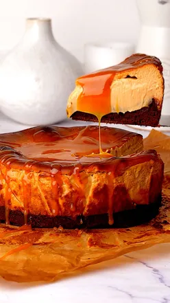 Salted caramel brownie Basque cheesecake topped with caramel drizzle, perfect dessert for caramel lovers.