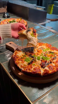 Delicious London Style pizza with caramelised cheese at Japes, Cheltenham, featuring Wicked Chickens flavor.